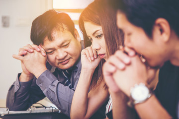 Thinking about business. Thoughtful mature man in formalwear holding hands clasped and looking away while sitting at his working place.