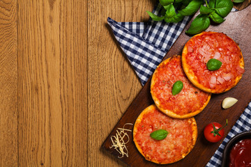 Mix of mini pizzas on wooden board