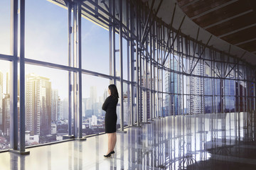 Back view of asian business woman relaxing while looking skyscraper