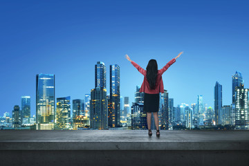 Fototapeta na wymiar Happy asian business woman standing on a edge a rooftop