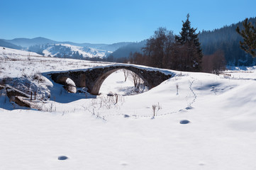 Fototapeta na wymiar Old Roman bridge covered from the snow in Bulgaria