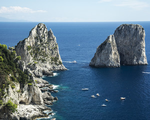 Obraz premium A sea landscape were some islets and rocks belonging to the coast surronded by several boats can be seen
