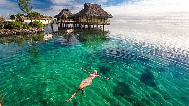 Young woman swimming in a coral lagoon
