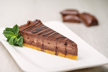 chocolate or coffee cheescake with mint leaf on white plate, gluten free cake, product photography for patisserie
