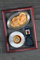 Tea with lemon, marmalade and a phone in a frame