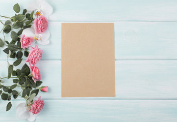 Wooden background with roses and orchid and empty notebook with place for text © julia_arda