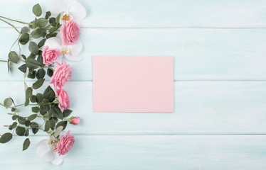 Wooden background with roses and orchid and empty notebook with place for text