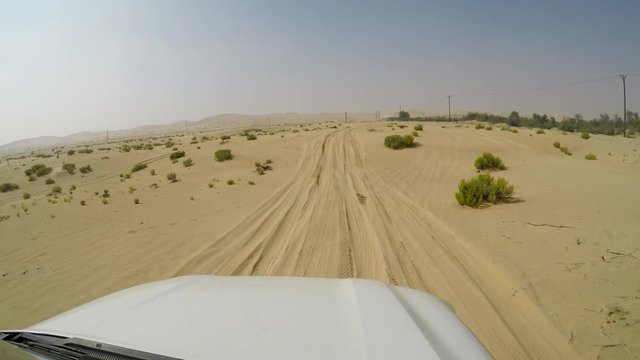 4x4 SUV car driving through the sand dunes in the desert of abu dhabi