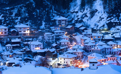 Snowy fairytale in Bulgaria. Night goes down over Shiroka Laka village, Bulgaria