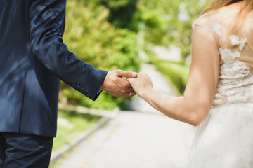 Bride and groom walking together holding their hands