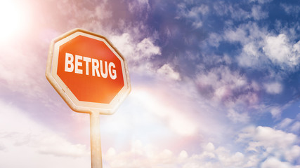 Betrug auf rotem Stoppschild vor blauem Wolkenhimmel