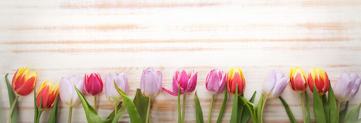 bouquet of tulips of spring flowers on old wooden board on holiday of Easter