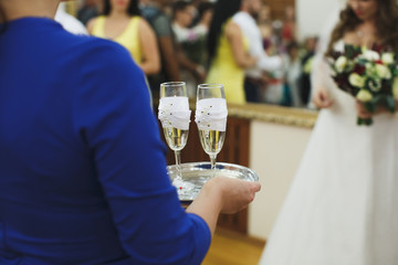bride and groom holding beautifully decorated wedding glasses with champaign