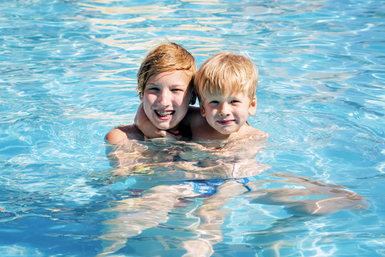 Two smiling brothers in the pool.Boys have a good time in aquapark in the summer