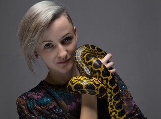Blond smiling woman holding anaconda