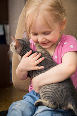 little girl hugging het cat