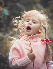 Little cute girl blowing dandelion.