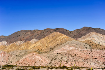 Coloured rock mountains. Hill of Seven Colors over Purmamarca village. Quebrada de Humahuaca valley, a UNESCO World Heritage Site, Argentina.