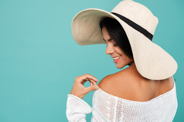 Back view of happy woman in hat standing and smiling