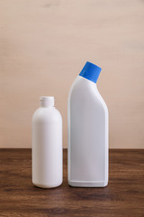 Mock-up plastic bottles. Mockup design for branding. Shampoo and washing wc cleaner. Front view. Wooden rustic board.