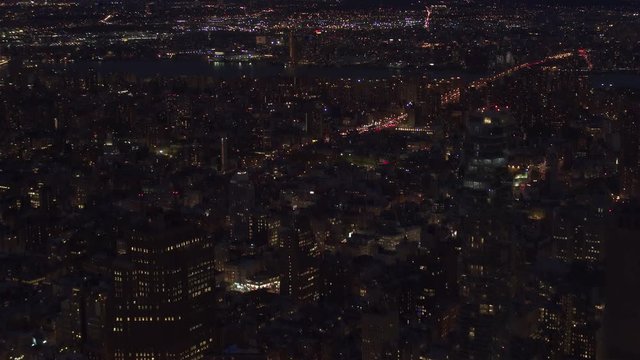 AERIAL HELI SHOT, ESTABLISHING SHOT: Flying above New York City East Village and Little Germany residential neighborhood towards Williamsburg Bridge jammed interstate during the rush hour after sunset