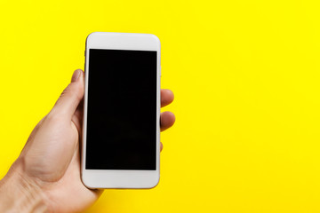 hand holding phone on on a yellow background.  clipping path inside
