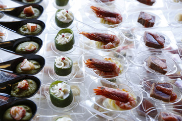 finger food: assortimento di vari piattini trasparenti con cucchiaino con dentro gamberi cozze tonno