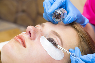 Woman on the procedure for eyelash extensions, eyelashes lamination 