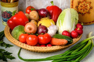 On the kitchen table, in the large wicker basket are a variety o