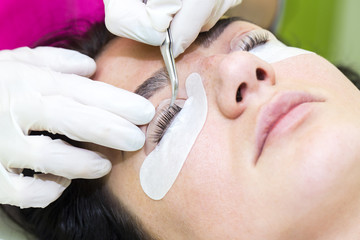 Woman on the procedure for eyelash extensions, eyelashes lamination 