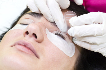 Woman on the procedure for eyelash extensions, eyelashes lamination 