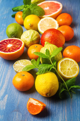 Citrus juice fruit and slices of orange, grapefruit, lemon, lime. Vitamin C. Wooden blue background.