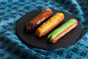 Group of french dessert Eclair on black background.
