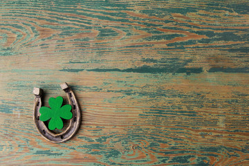 St. Patricks day, lucky charms. Horesechoe and shamrock on wooden background