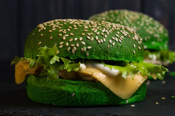 fresh green tasty burger on black background