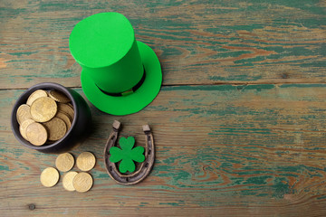 Happy St Patricks Day leprechaun hat with gold coins and lucky charms on vintage style green wood...