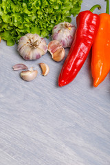 Fresh vegetables. Pepper, green salad and garlic. Fresh natural food. Organic vegetables on wooden background.