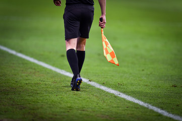 Assistant referee moving along the sideline during a soccer match