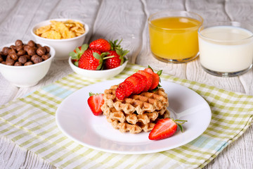 breakfast: Waffels with strawberry, orange juice and milk
