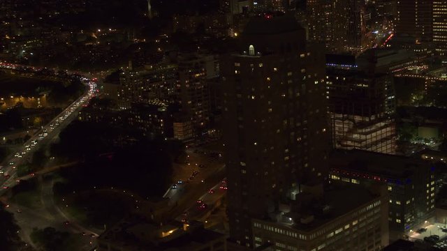 AERIAL HELI SHOT: Flying above lit up with lights busy Manhattan Bridge overpass underpass interchange and interstate highway in the burough of Brooklyn, New York City. Cars commuting to work at night