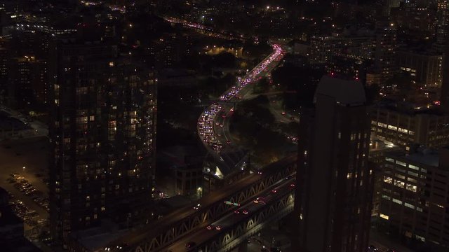 AERIAL HELI SHOT, CLOSE UP: Flying above busy freeway full of vehicles commuting during the evening rush hour in DUMBO neighborhood. Manhattan and Brooklyn Bridge overpass underpass interchange
