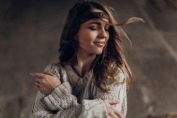Beautiful hipster woman in boho indie clothes, posing in winter outdoor, face closeup, wind playing with hair