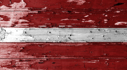 Latvia flag on wood texture background with old paint peels