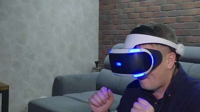 Man wearing virtual reality goggles. Studio shot, couch.Technology VR - Mature businessman wearing virtual reality technology googles