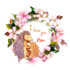 Hedgehog hugging her baby in floral wreath. Card for Mothers day with text I love you Mom . Watercolor