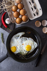 fried eggs iron frying pan rosemary spice pepper
