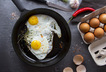 fried eggs iron frying pan rosemary spice pepper
