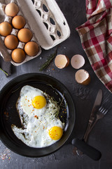 fried eggs iron frying pan rosemary spice pepper
