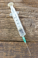 Syringe on wooden background