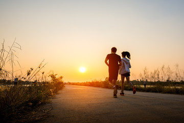 silhouette man and woman running on road at sunset background